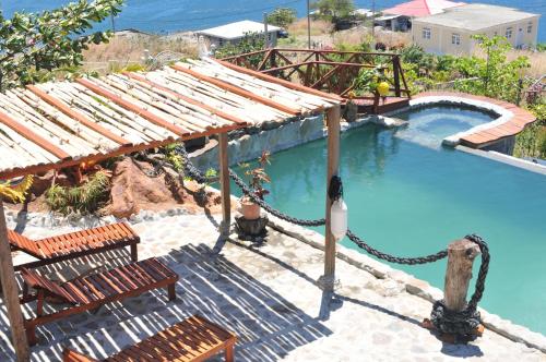 uma piscina com duas cadeiras e uma corda à volta em Mango Island Lodges em Saint Joseph