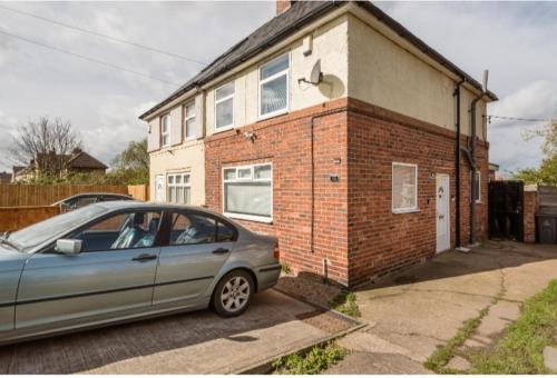 een auto geparkeerd voor een bakstenen huis bij Elegant room In a private House in Rotherham