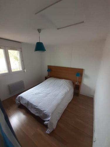 une chambre avec un lit dans une pièce blanche dans l'établissement Maisonnette à Vieux-Boucau, à Soustons