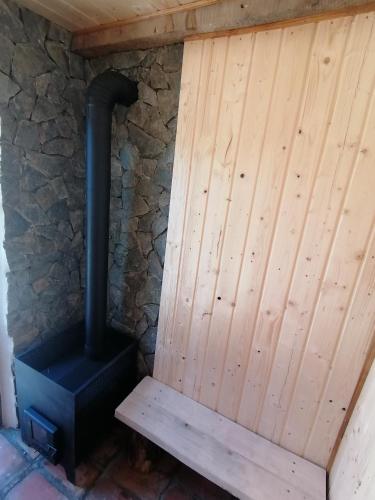 a wood stove sitting next to a stone wall at Borlova /Muntele Mic in Borlova