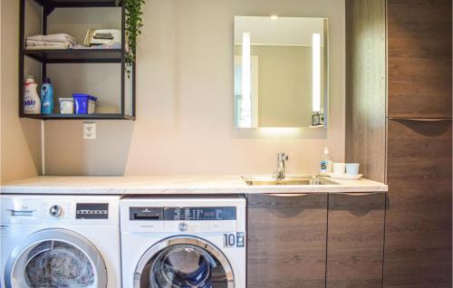 a bathroom with a washing machine and a sink at 5 Bedroom Lovely Home In Bjoa in Utbjoa