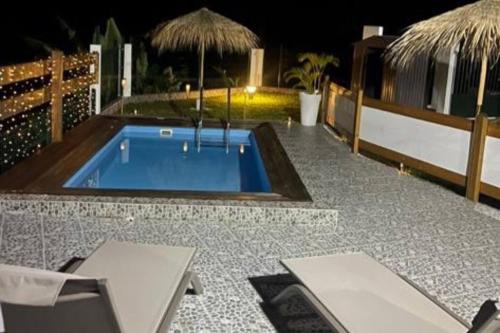 a swimming pool on top of a patio at night at Palmier bungalow- piscine in Gros-Morne