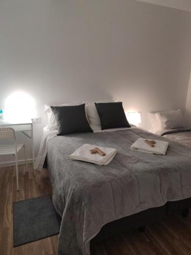 a bedroom with a bed with two towels on it at Habtiar Guest House in Braga