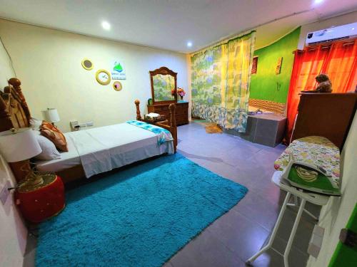 1 dormitorio con cama y alfombra azul en Comfort Suites - Special, en Choiseul