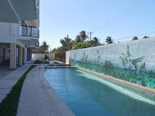 a swimming pool in front of a building at Condo vista al mar, alberca rooftop Chixchulub in Chicxulub