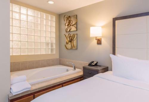 a bedroom with a bed and a bath tub at CopperLeaf Boutique Hotel & Spa; BW Premier Collection in Appleton