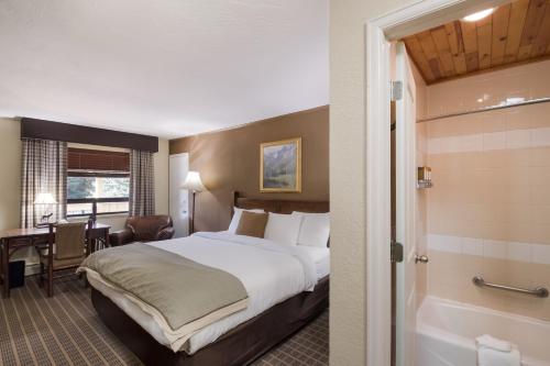 a hotel room with a large bed and a bathroom at The Inn at Tomichi Village in Gunnison