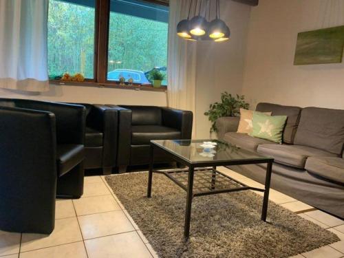 - un salon avec un canapé et une table basse dans l'établissement Ferienhaus in Feriendorf Silbersee mit Offenem Kamin, à Frielendorf