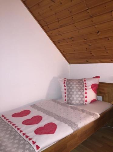 Un dormitorio con una cama con corazones rojos. en Ferienhaus in Feriendorf Silbersee mit Offenem Kamin en Frielendorf