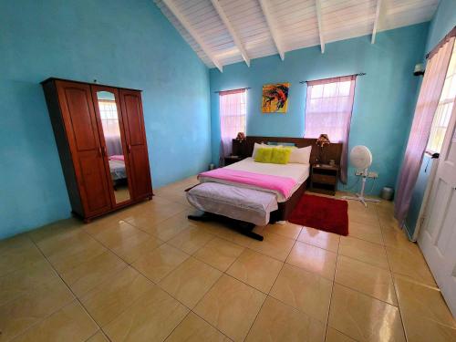 a bedroom with a bed in a blue room at Comfort Suites - One Bedroom Apartment in Choiseul