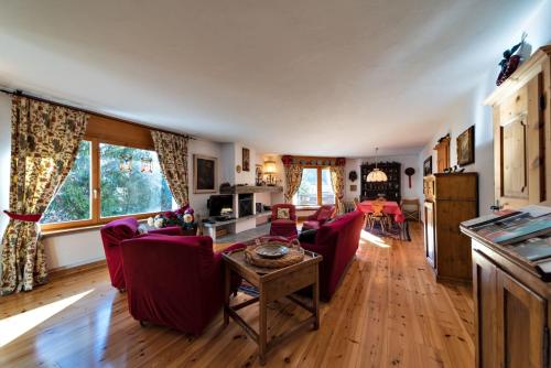 a living room with red chairs and a table at Chesa Pradash - Celerina in Celerina