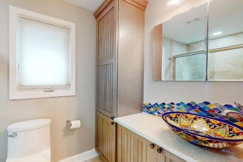 La salle de bains est pourvue d'un lavabo et d'un bol sur un comptoir. dans l'établissement Valentine Creek Retreat, à Odenton