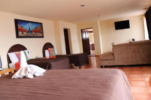 a hotel room with a bed and a couch at Hotel Chocolate Suites in Guanajuato