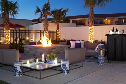 a fire pit in the middle of a patio with palm trees at TownePlace Suites by Marriott Galveston Island in Galveston