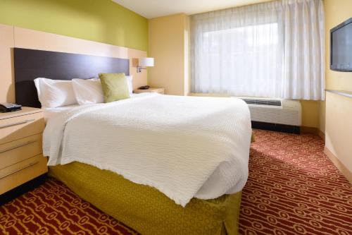 a hotel room with a large bed and a window at TownePlace Suites by Marriott Galveston Island in Galveston