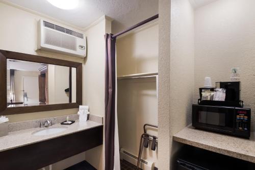 a bathroom with a sink and a microwave at The Inn at Tomichi Village in Gunnison