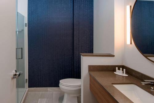 a bathroom with a toilet and a sink and a mirror at Fairfield Inn & Suites by Marriott Dallas Love Field in Dallas