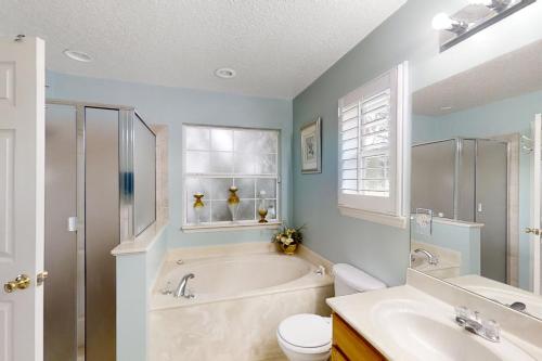 a bathroom with a tub and a toilet and a sink at The Home on Tyson Lake Drive in Jacksonville