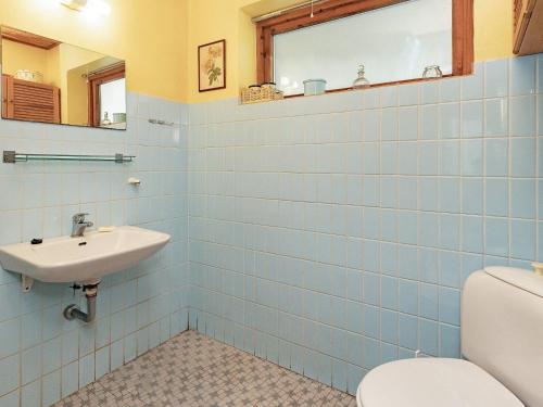 Sønder YdbyにあるHoliday Home Pøt Strandby XIVの青いタイル張りのバスルーム(トイレ、シンク付)