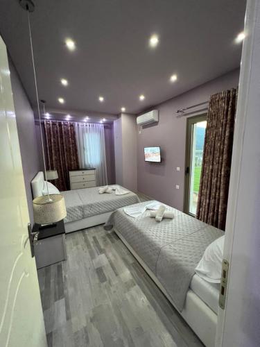 a bedroom with two beds and a window at Villa Klajdi in Përmet