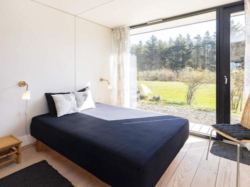 ein Schlafzimmer mit einem Bett und einem großen Fenster in der Unterkunft Holiday home Øster Assels VII in Øster Assels
