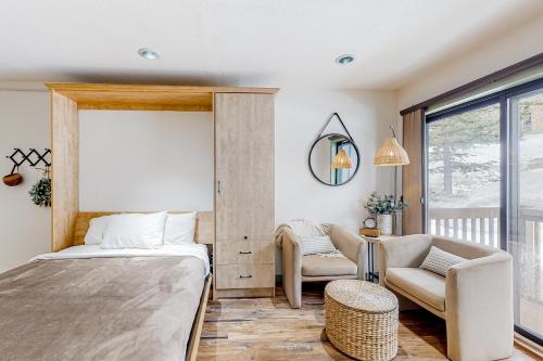 een slaapkamer met een bed, een stoel en een raam bij Cascade Village 308 in Durango Mountain Resort