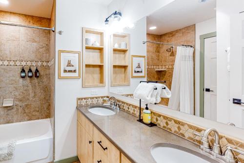 y baño con 2 lavabos, bañera y ducha. en Cascade Village 308, en Durango Mountain Resort