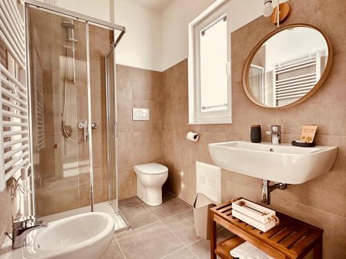 een badkamer met een wastafel, een toilet en een spiegel bij Agriturismo Il Querciolo in Grosseto