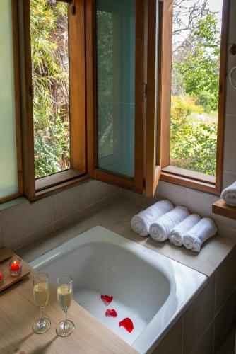 a bathroom with a tub with two glasses of wine at Casa Cielo en Chena Magica in Maipú