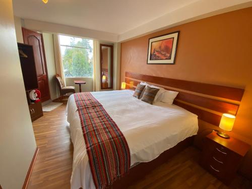 ein Schlafzimmer mit einem großen Bett in einem Zimmer in der Unterkunft Chinchero Boutique Hotel & Tours in Chincheros
