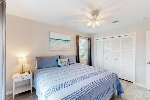 a bedroom with a bed and a ceiling fan at Flood Reef Getaway in Pensacola