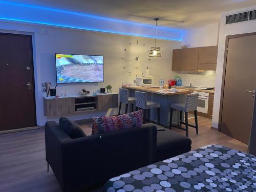 a living room with a couch and a kitchen with a tv at Appartamento accogliente vicino stazione in Desio