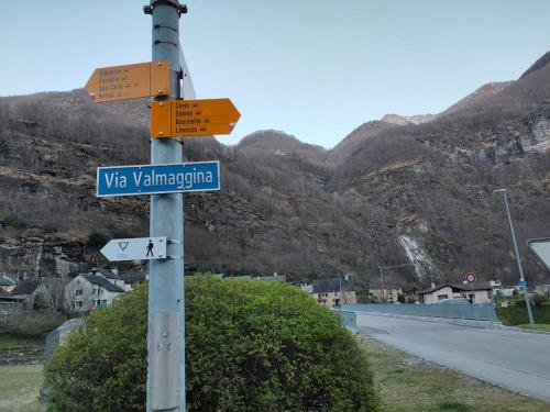 a pole with a street sign on the side of a road at Armonia edificio storico del 1563. in Cevio