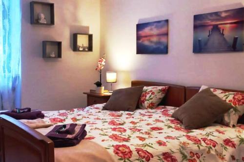 a bedroom with a bed with a flowered blanket at Armonia edificio storico del 1563. in Cevio