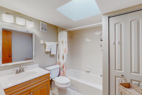 een badkamer met een toilet, een wastafel en een bad bij Gulf's Hidden Treasure in St Pete Beach