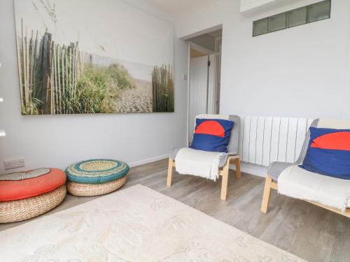 a living room with two chairs and a table at Wootton Gray in Mousehole