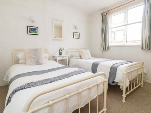 um quarto com 2 camas e uma janela em Wootton Gray em Mousehole