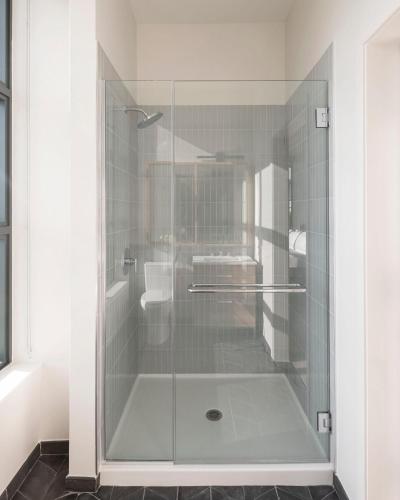a shower with a glass door in a bathroom at ROOST Tampa in Tampa