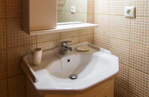 y baño con lavabo blanco y espejo. en Annas Sea & City, en Palaiochóra