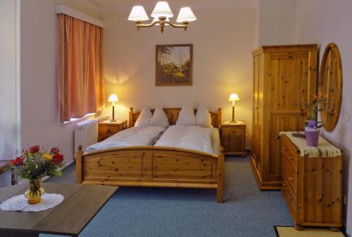 ein Schlafzimmer mit einem großen Holzbett und einem Tisch in der Unterkunft Parkvilla Bad Lausick in Bad Lausick