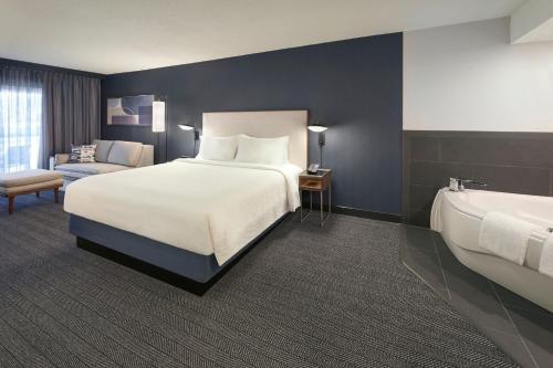 密西沙加的住宿－多倫多米西索加/梅多維爾萬怡酒店，酒店客房配有一张床和浴缸。