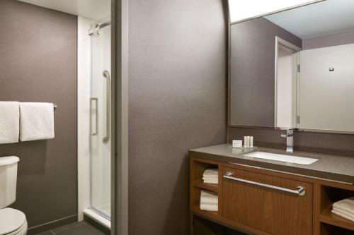 W łazience znajduje się umywalka, toaleta i lustro. w obiekcie Courtyard by Marriott Toronto Mississauga/Meadowvale w mieście Mississauga