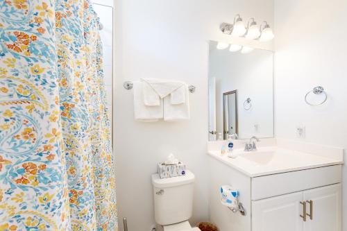 a bathroom with a toilet and a sink and a shower curtain at Sea Oaks --- 4 Osprey Ln in Ocean View