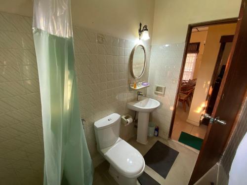 a bathroom with a toilet and a sink and a mirror at Oasis Colombo in Colombo