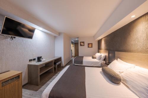 Säng eller sängar i ett rum på Hotel Malibu