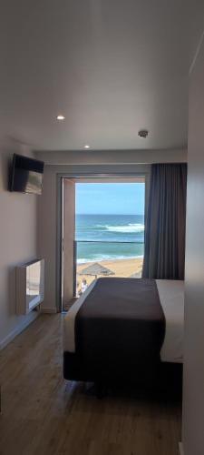 a bedroom with a bed and a view of the ocean at Promar - Eco Beach & Spa Hotel in Maceira