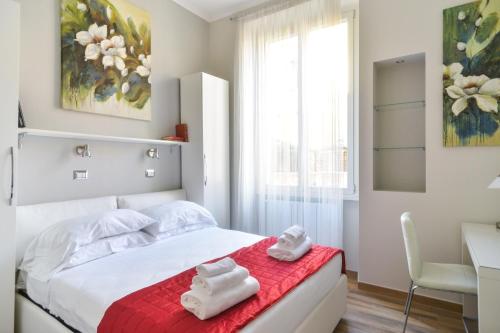 una camera da letto con un letto con asciugamani su una coperta rossa di Lata Luxury Apartment a Roma