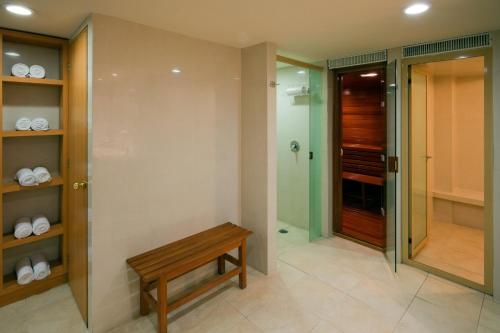 baño con banco y ducha a ras de suelo en Holiday Inn Mexico City - Trade Center, an IHG Hotel en Ciudad de México