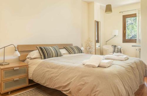 a bedroom with a large bed with two towels on it at Chalet El Molino de Castiello in Castiello de Jaca
