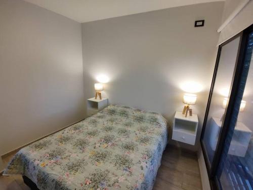1 dormitorio con 1 cama y 2 mesitas de noche con lámparas en Departamento 3 personas en Las Heras